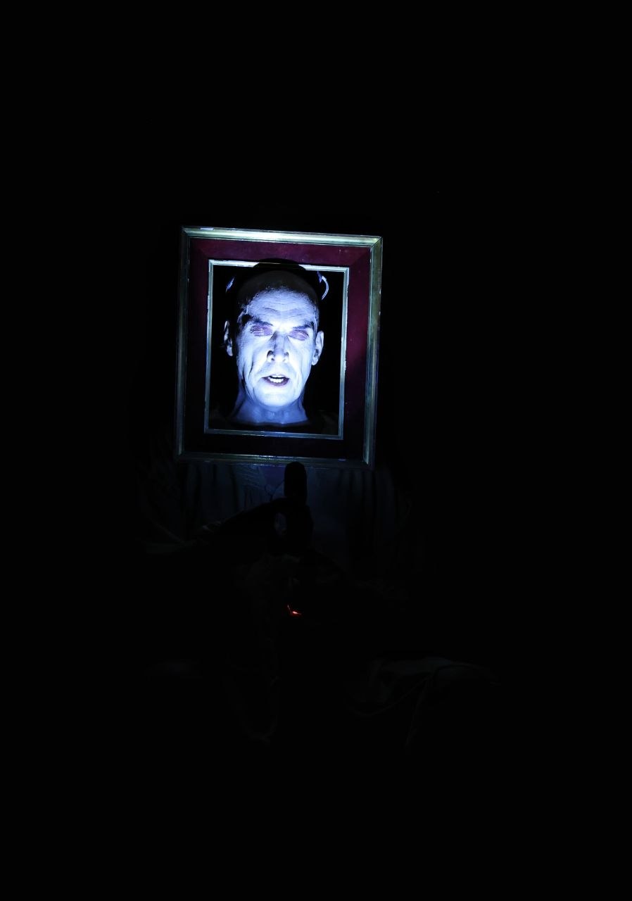 El rostro de Pompeyo Audivert iluminado dentro de un marco en Habitación Macbeth.
